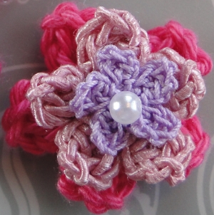 A three layer flower with a pearly bead in the center