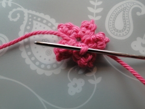 weaving the tail end into the back of the first petal