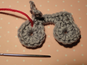 Crimson yarn contrasting with the gray bike