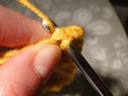Pulling yarn through stitch