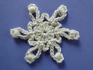 Cream six point flower with bullions at the ends of the points and loops in between