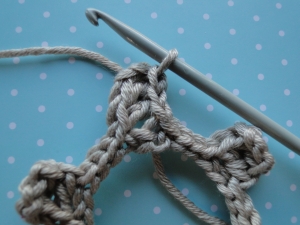 Slip stitches up to the top of the first cog.